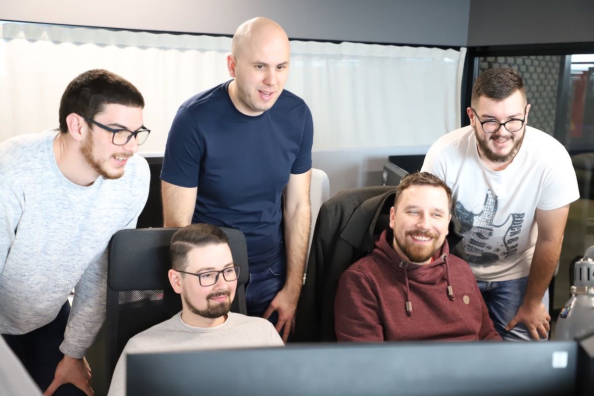 Five people looking at a computer